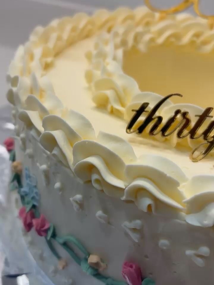 A cream ruffle cake with a gold topper